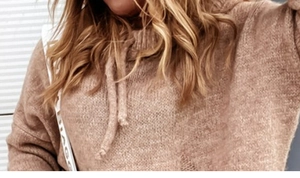 Close-up of camel knit sweater featuring a round neck with decorative drawstring detail