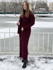 Detail of burgundy cable knit long cardigan with belt and side slits in snow setting