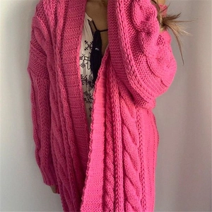 Close-up of chunky cable knit texture on a long rose pink cardigan sweater for women