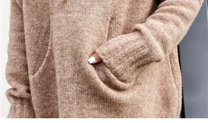 Detailed macro view of fuzzy knit sweater fabric with kangaroo pocket and ribbed cuffs