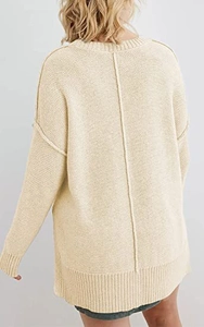 Detailansicht eines beigen Oversized-Strickpullovers mit Rückennaht und geripptem Saum