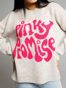 Close-up detail of pink pinky promise lettering on grey knit long sleeve sweater