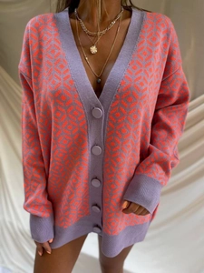 Detail view of purple and orange color-block plaid knit cardigan with purple buttons