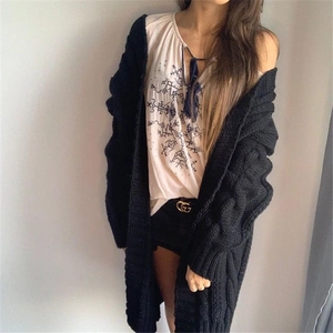 Detail of loose cable knit texture on women's long black cardigan sweater