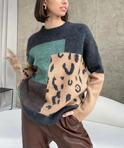 Detail of loose-fit round neck knit sweater featuring geometric patchwork and leopard print
