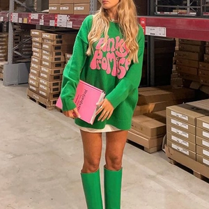 Detail view of oversized green sweater featuring pink 'Pink Promise' jacquard lettering