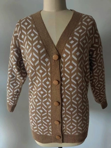 Detail of the V-neck knit cardigan with brown and white argyle pattern and round buttons