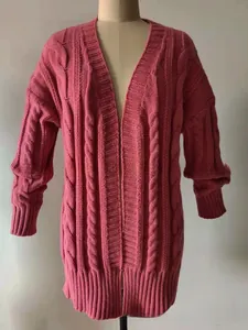 Detailed close-up of rose red chunky cable knit cardigan texture and ribbed cuff design