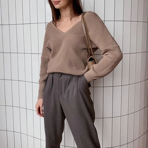 Women's V-neck loose knit sweater in earth tones paired with high-waist trousers