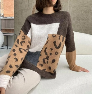 Detail of color-block leopard print sweater with cozy knit texture and ribbed crewneck