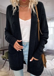 Detail of black cable knit cardigan showing thick texture and large side pockets on long sleeve