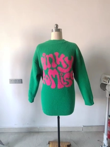 Detail view of green knit sweater featuring pink pinky promise text pattern and round neck