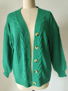 Vue détaillée de la maille torsadée et des boutons en écaille du gilet vert