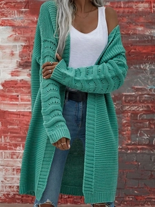 Dettaglio del cardigan in maglia grossa verde pavone con motivi traforati sulle maniche