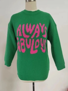 Detail of ribbed crewneck and pink Always Fabulous jacquard text on green knit sweater