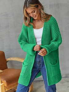 Detail of bright green chunky knit cardigan with long sleeves and large side pockets