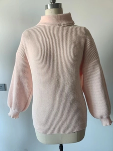 Detailed view of pink ribbed knit sweater featuring high neck and puffed lantern sleeves