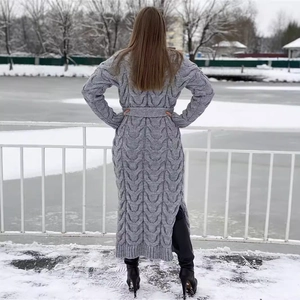 Long gray cable-knit cardigan with belt and side slits in a snowy outdoor scene