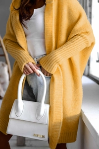 Detail of chunky knit texture on a bright yellow longline hooded cardigan sweater