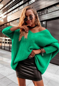 Close-up of bright green oversized knit sweater featuring batwing sleeves and round neck