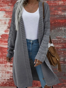 Dettaglio del cardigan grigio in maglia grossa con motivi traforati e polsini