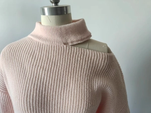 Detail of light pink high-neck knit sweater featuring a stylish shoulder cut-out design