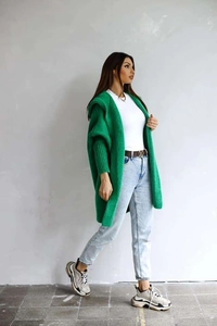 Detail of emerald green knitted cardigan with batwing sleeves and ribbed cuffs close-up