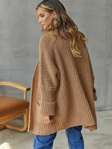 Close-up of women's long camel knit cardigan showing ribbed texture and large pockets