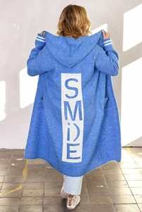 Dettaglio macro del cardigan celeste con cappuccio e stampa SMILE sulla parte posteriore