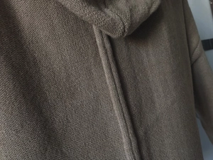 Detail of coffee-colored knitted fabric showing fine mechanical texture and stitching