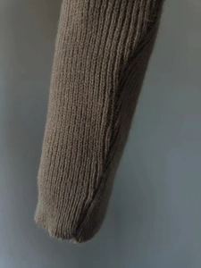 Close-up of dark brown ribbed knit cuffs with fuzzy wool texture and premium craftsmanship