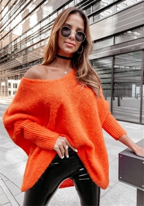 Detail of bright orange oversized chunky knit sweater with off-shoulder V-neck design