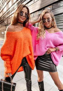 Close-up of bright orange and pink oversized knit sweaters with stylish off-shoulder necklines