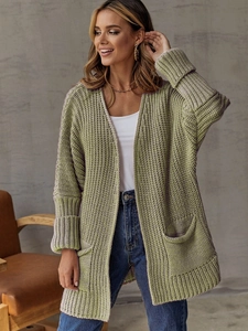 Detail of chunky grass green knit cardigan featuring vertical rib texture and side pockets