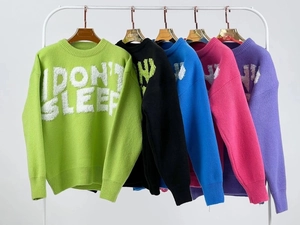 Detail view of five colored knit sweaters with I DON'T SLEEP 3D embossed lettering design