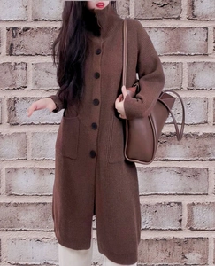 Detailed close-up of brown knit cardigan with black buttons and practical front pockets