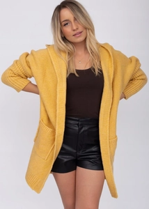 Detail view of yellow hooded knit cardigan featuring chunky knit texture and large pockets