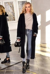 Dettaglio del cardigan nero in maglia con strisce bianche sui polsini e cappuccio largo