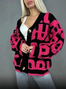 Détail du cardigan à col en V avec motifs de lettres roses et noires et boutons dorés