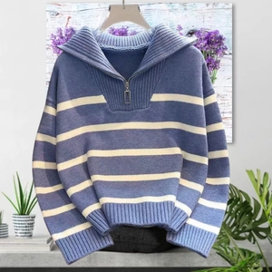 Detail of blue and white striped knit sweater with half-zip collar and ribbed cuffs