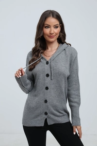 Detailed close-up of grey knitted cardigan with black buttons and ribbed cuffs texture
