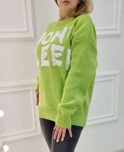 Detail shot of green knit sweater with fuzzy white embossed lettering on the chest