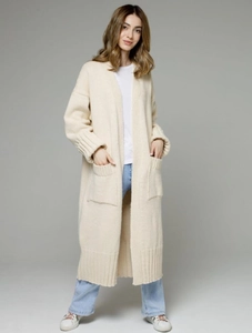 Detail of cream oversized knit cardigan featuring large front pockets and ribbed cuffs