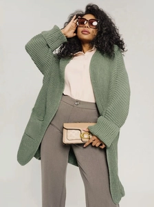 Close-up of chunky knit grass green cardigan with ribbed cuffs and large side pockets