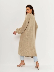 Detail view of beige long chunky knit cardigan showing ribbed cuffs and drape
