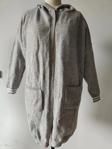 Detail of grey knitted cardigan showing dual front pockets and striped elastic cuffs