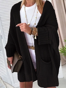 Detailansicht der schwarzen Grobstrickjacke in Übergröße mit Wabenmuster und Taschen