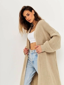 Detailed macro view of the beige chunky knit cardigan showing ribbed cuffs and texture