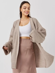 Detail of chunky knit beige oversized cardigan with large functional front pockets