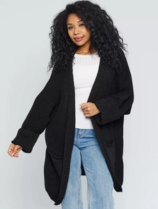 Close-up of black oversized knit cardigan featuring large pockets and textured fabric